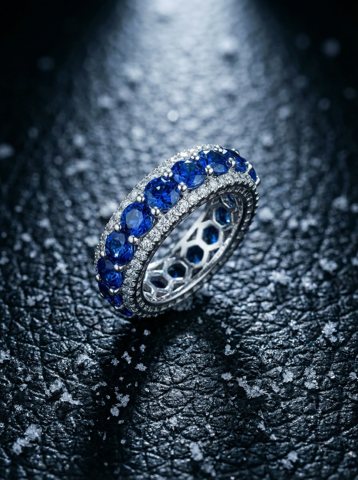 Anello su pelle nera, luce laterale, texture e contrasto