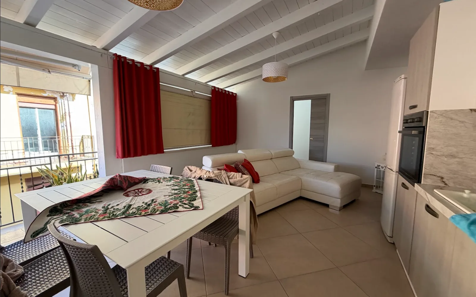 Veranda con tende scure e arredo accostato, prima