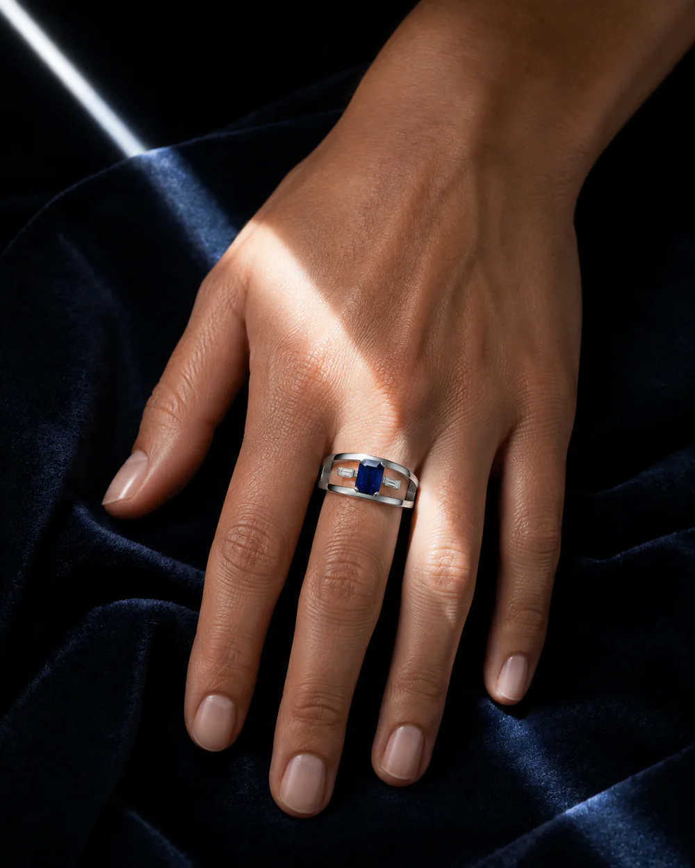 Anello con zaffiro indossato su una composizione blu notte