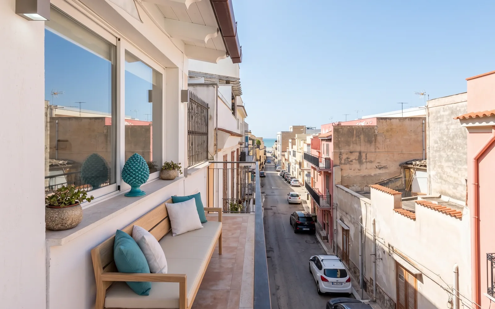 Stesso balcone arredato con seduta e cuscini, dopo