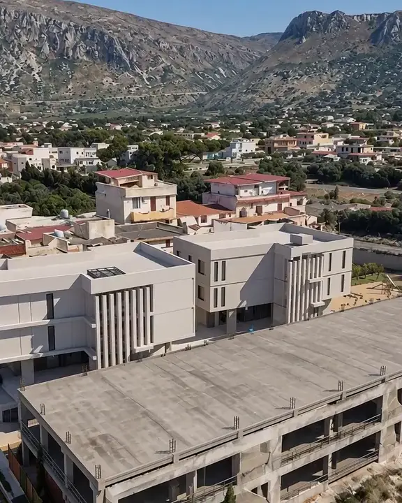Palazzine via Verga: volo sulle palazzine con le montagne dietro